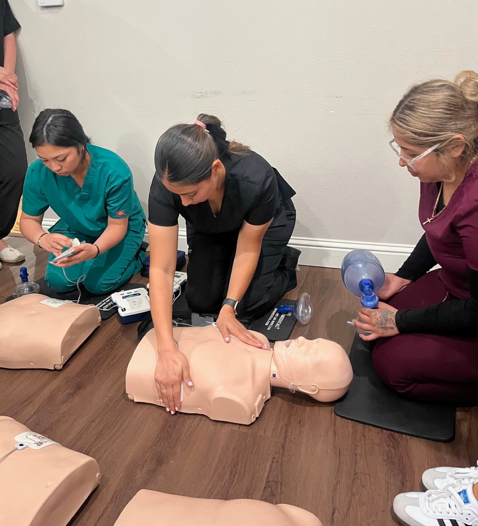 Students practicing CPR compressions on training manikins.