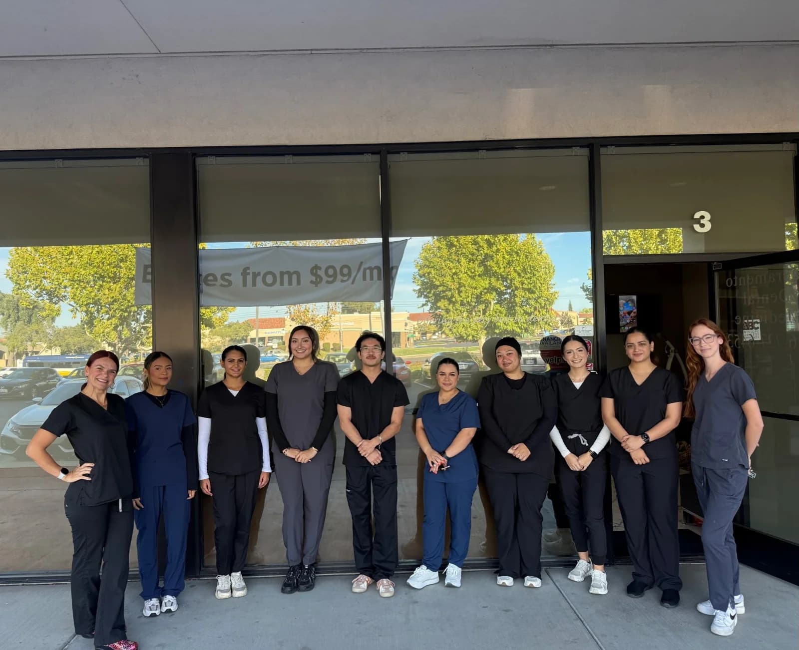 New dental assisting students in scrubs gathered outside the Roseville Dental Academy entrance.