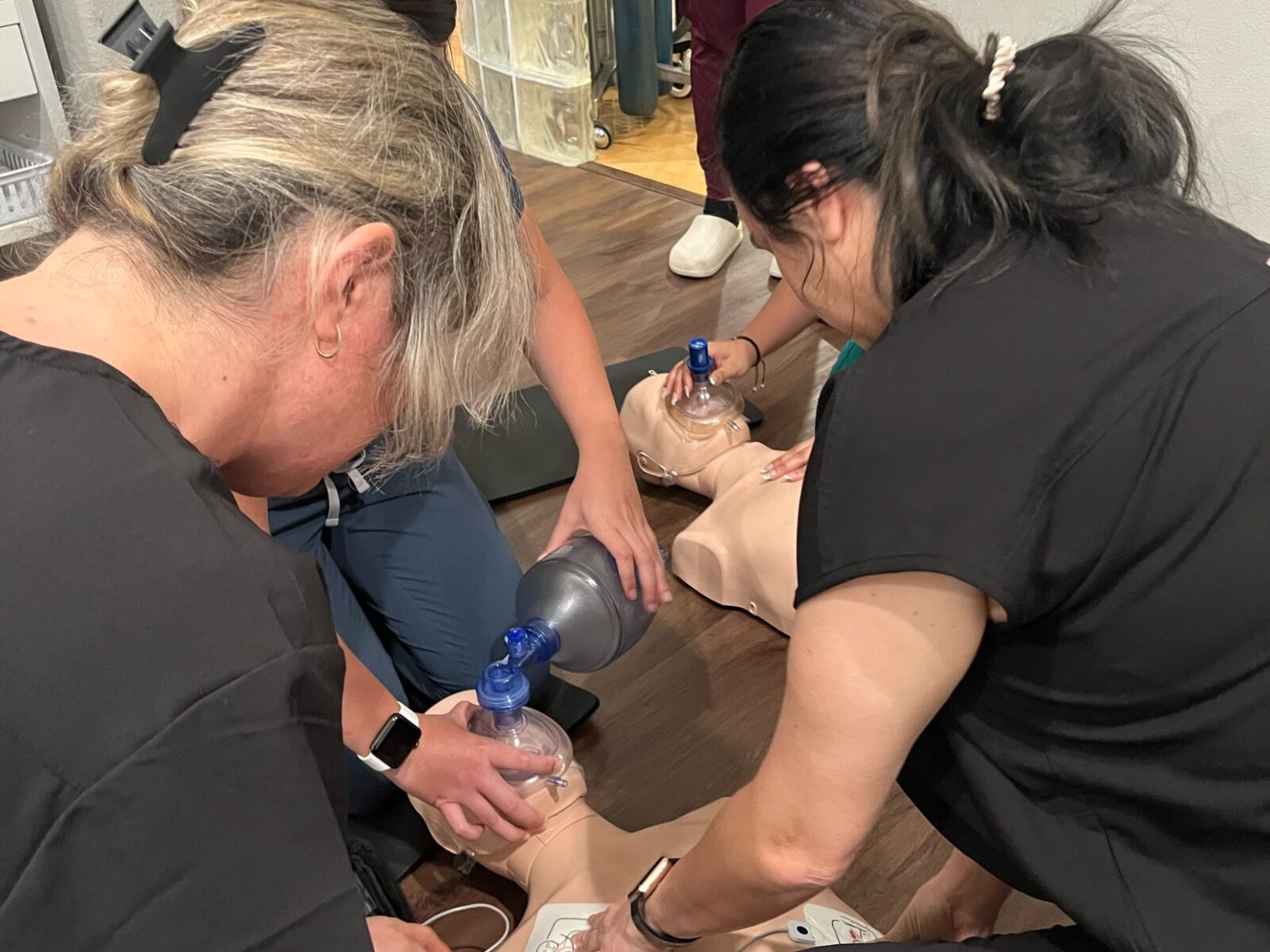 Students practicing BLS skills with training manikins
