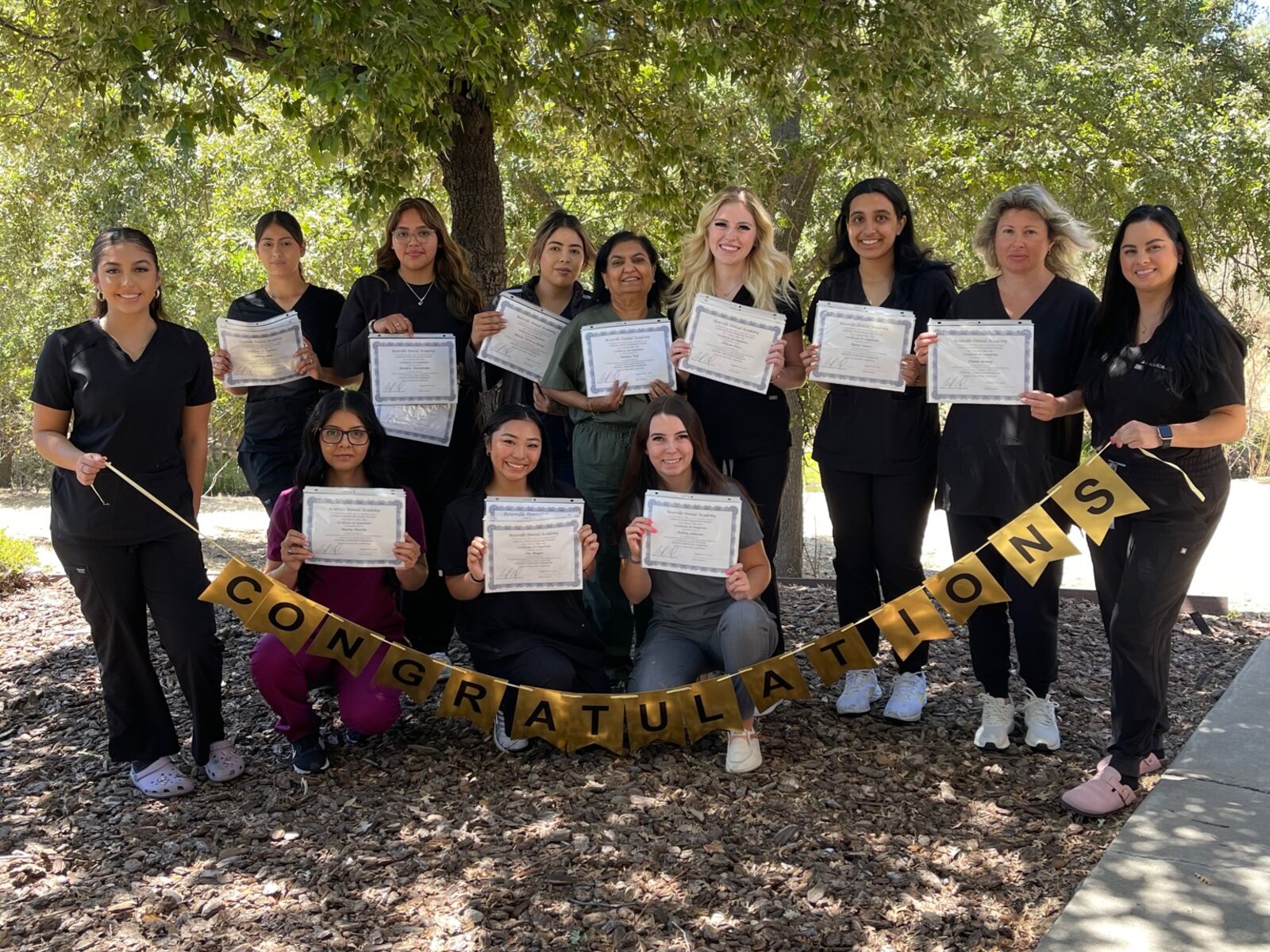 Recent Roseville Dental Academy students holding completion certificates