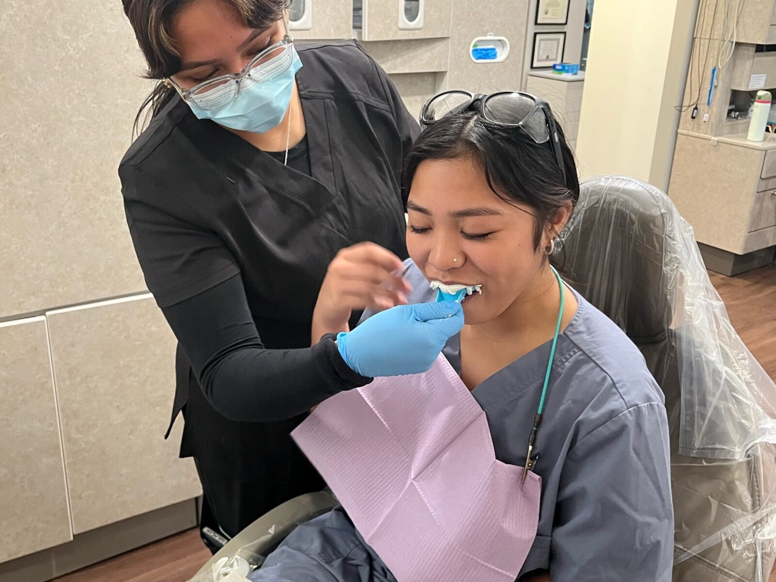 Roseville Dental Academy student practicing chairside technique with instructor support.
